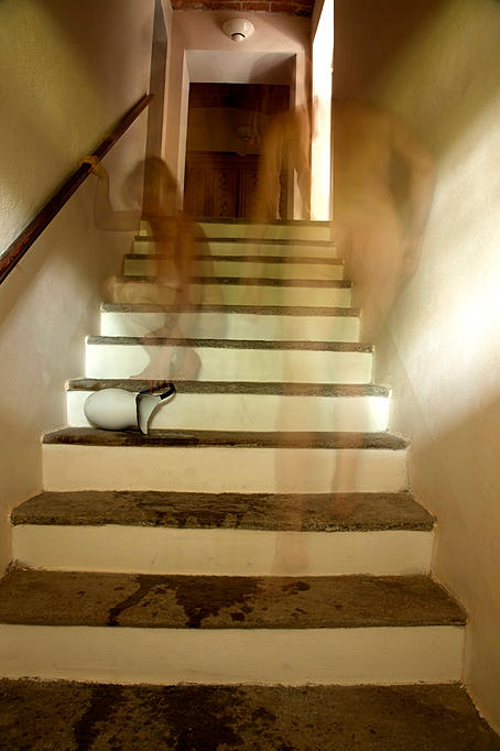 ghostly images of a woman and man climbing stairs