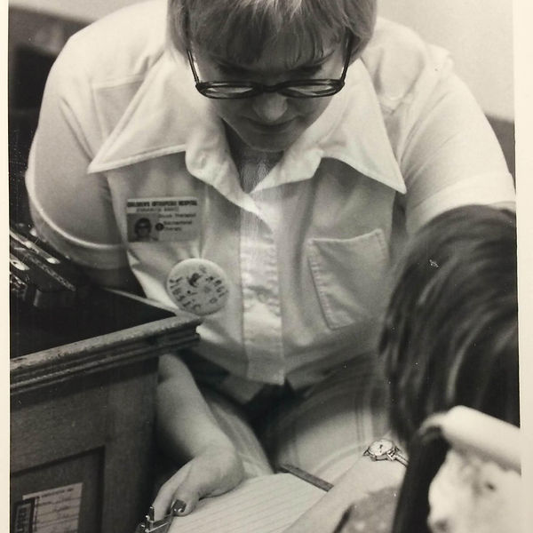 A black and white photo of Jennarose Rantz making music with a child.