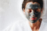 Woman relaxing with a charcoal facial ma