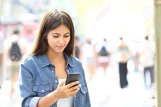 108745422-beautiful-relaxed-teen-using-a-smart-phone-walking-in-the-street.jpg