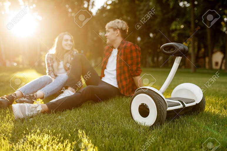 129320024-young-couple-sitting-on-the-grass-near-gyro-board.jpeg