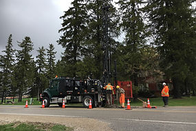 Truck-mounted drill-rig advancing boreholes in roadway