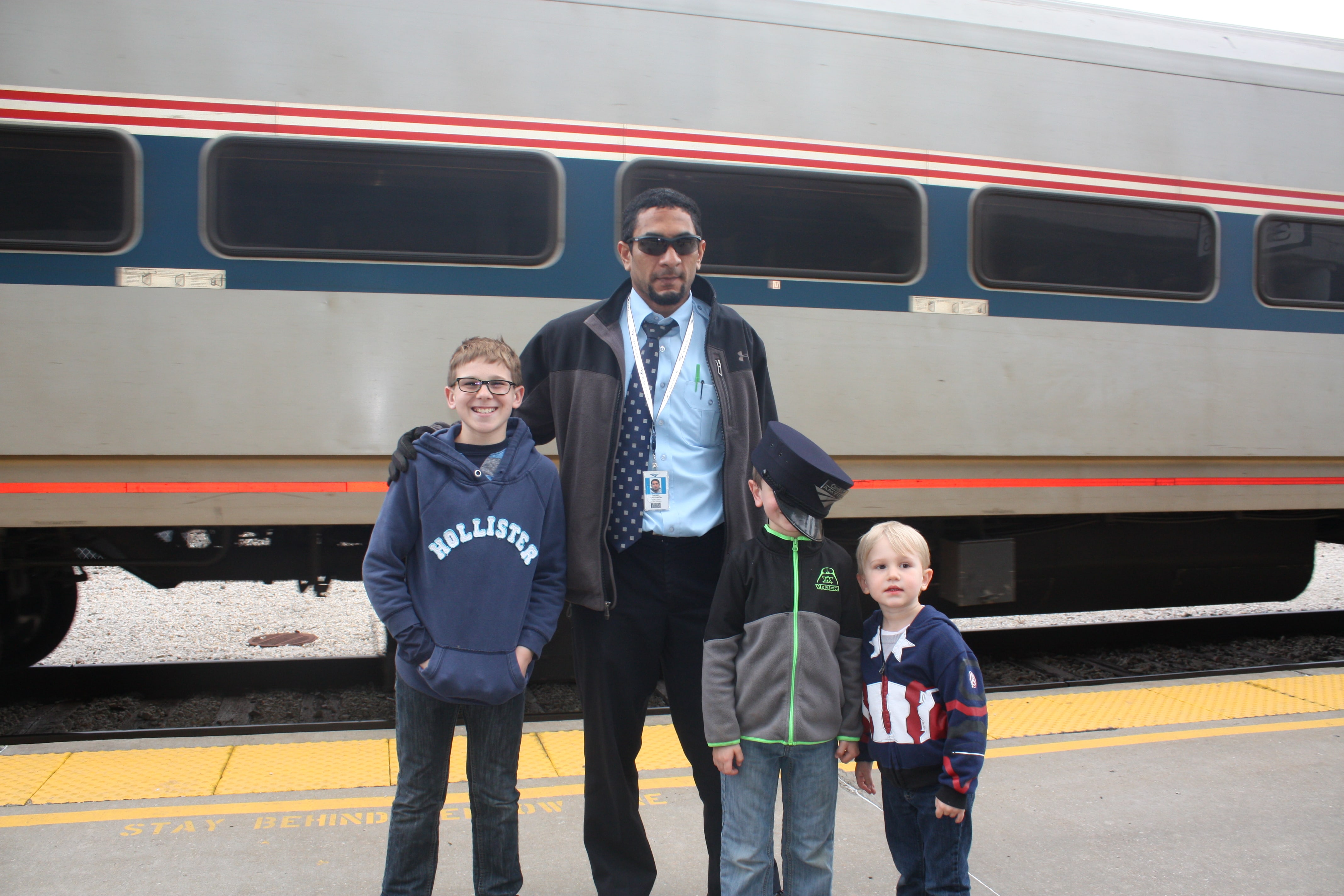 3 boys with conductor of Amtrak train