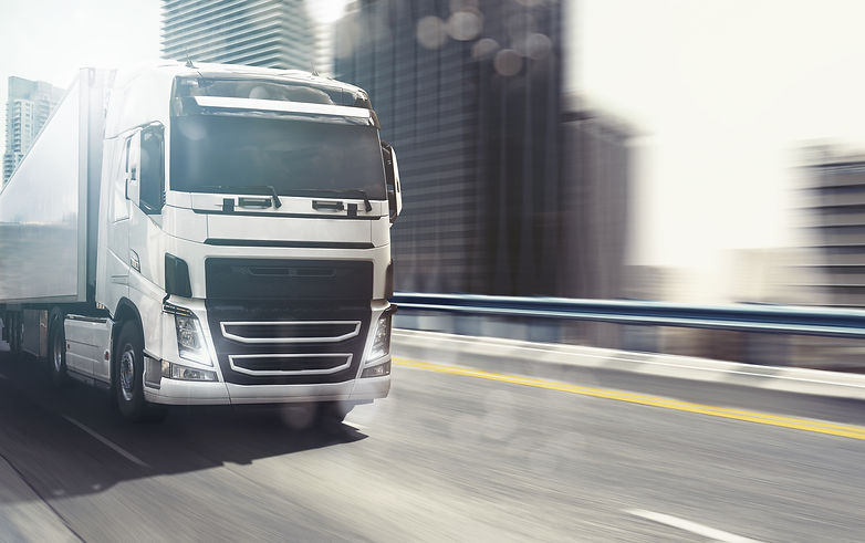 white-truck-moving-fast-highway-with-modern-city.jpg
