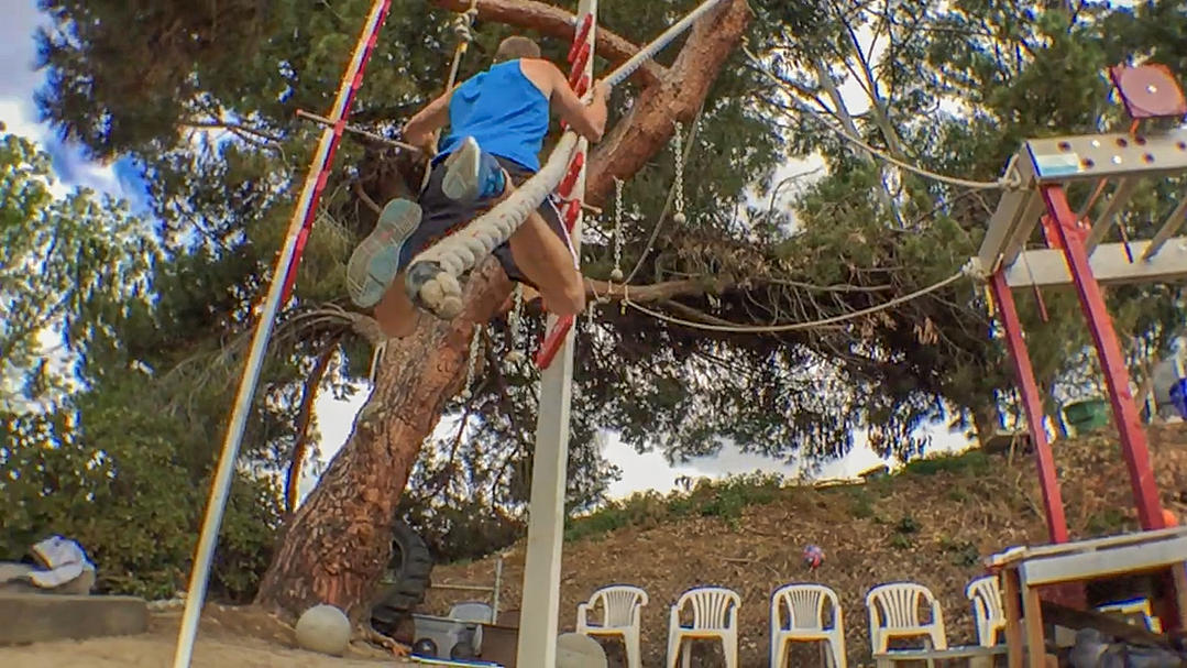 Cory Dzbinski leaps from the rope to the salmon ladder.