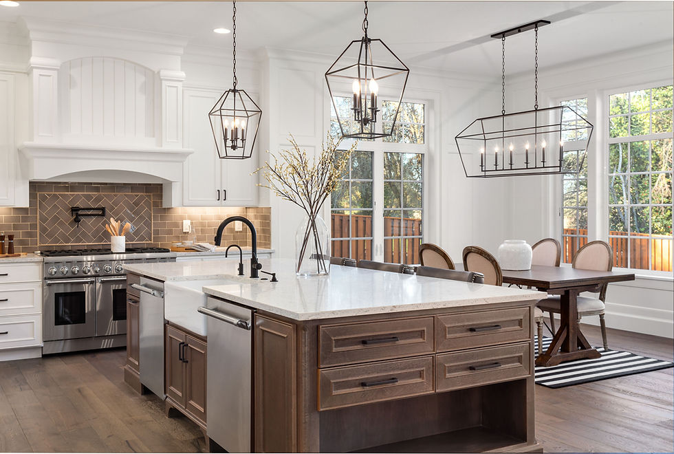 A white farmhouse kitchen with a centre island with stone countertop, subway tile backspash, and wood or laminte floor coverings.
