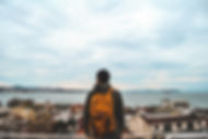 man-wearing-black-jacket-and-brown-backp