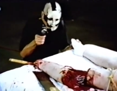 Masked man filming a woman leg being sawn of in American Guinea Pig Bouquet of Guts and Gore horror film