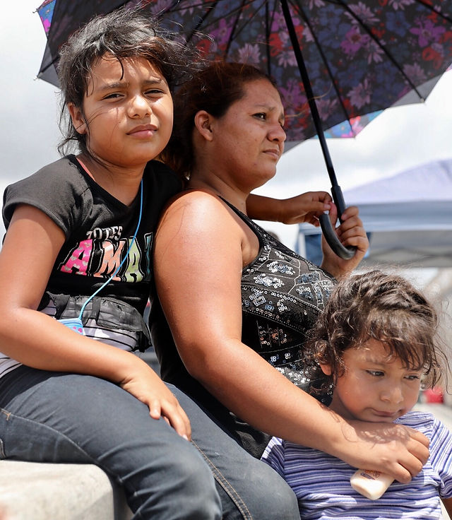 Two young girls and their mother. Immigrants seeking asylum. Waiting at bridge at the border in Texas.