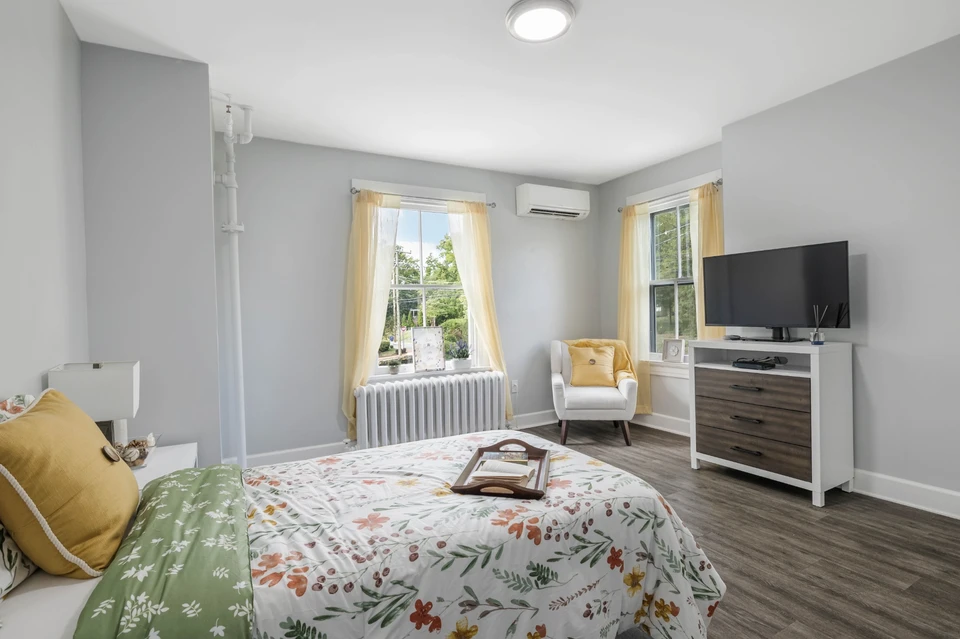 Reflections Leesburg bright furnished model room with reading chair