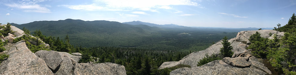 A rocky summit with distant peaks in the background.