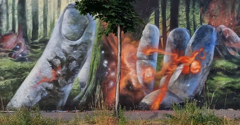 Large mural in Switzerland of stone hands holding trees which are shooting up from the land, creation stories, nature and rebirth. 