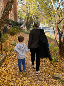 Erin and son walking in fall with leaves on sidewalk