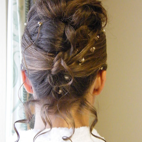 Elegant updo hairstyle with curls and pearl hairpins, viewed from the back