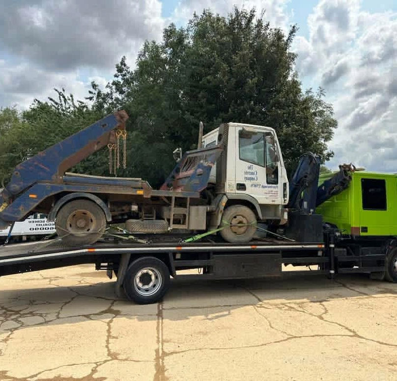 Green recovery vehicle towing a van