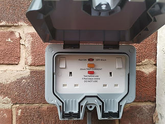 Outdoor waterproof electrical socket installed on brick wall exterior