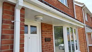 Front entrance of brick house with white porch and guttering