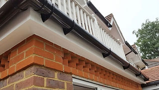 White guttering and fascias fitted along brick house roofline