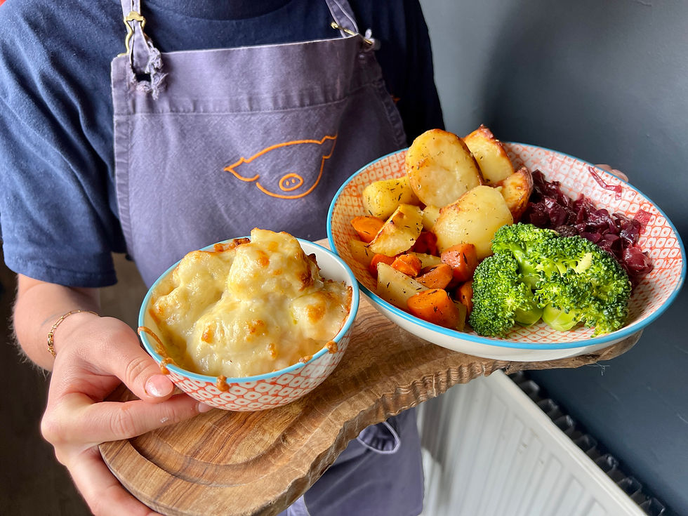 A person wearing a blue shirt and apron holds a wooden board with two bowls