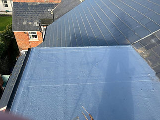 View from a roof, showing a flat gray section and contrasting angled slates