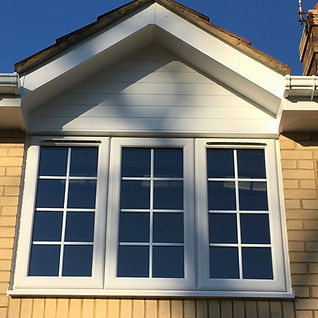 White uPVC windows installed on traditional brick house exterior