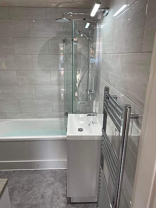 smart modern bathroom with large grey metro tiles and wall mounted heated towel rail