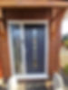 Grey composite front door installed on brick house entrance