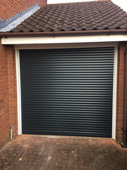 Anthracite grey roller garage door with a white outer frame