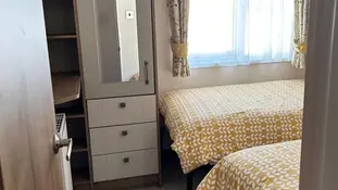 bedroom with two beds with fitted furniture and door in the photo