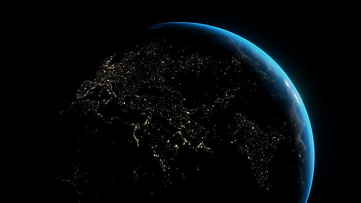 Earth at night from space, with glowing city lights across continents.