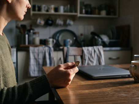 Woman holding coin at table, symbolising key investing versus gambling decision