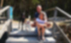 Ein Mann und mit seiner Frau sitzen neben zwei Hunden auf einer Holztreppe am Waldrand