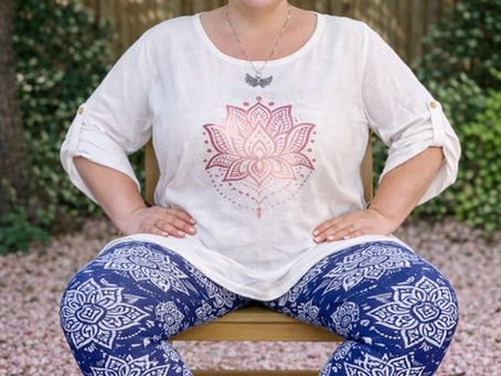 Callie sitting on a chair, wearing a white t-shirt and blue leggings with a white pattern.