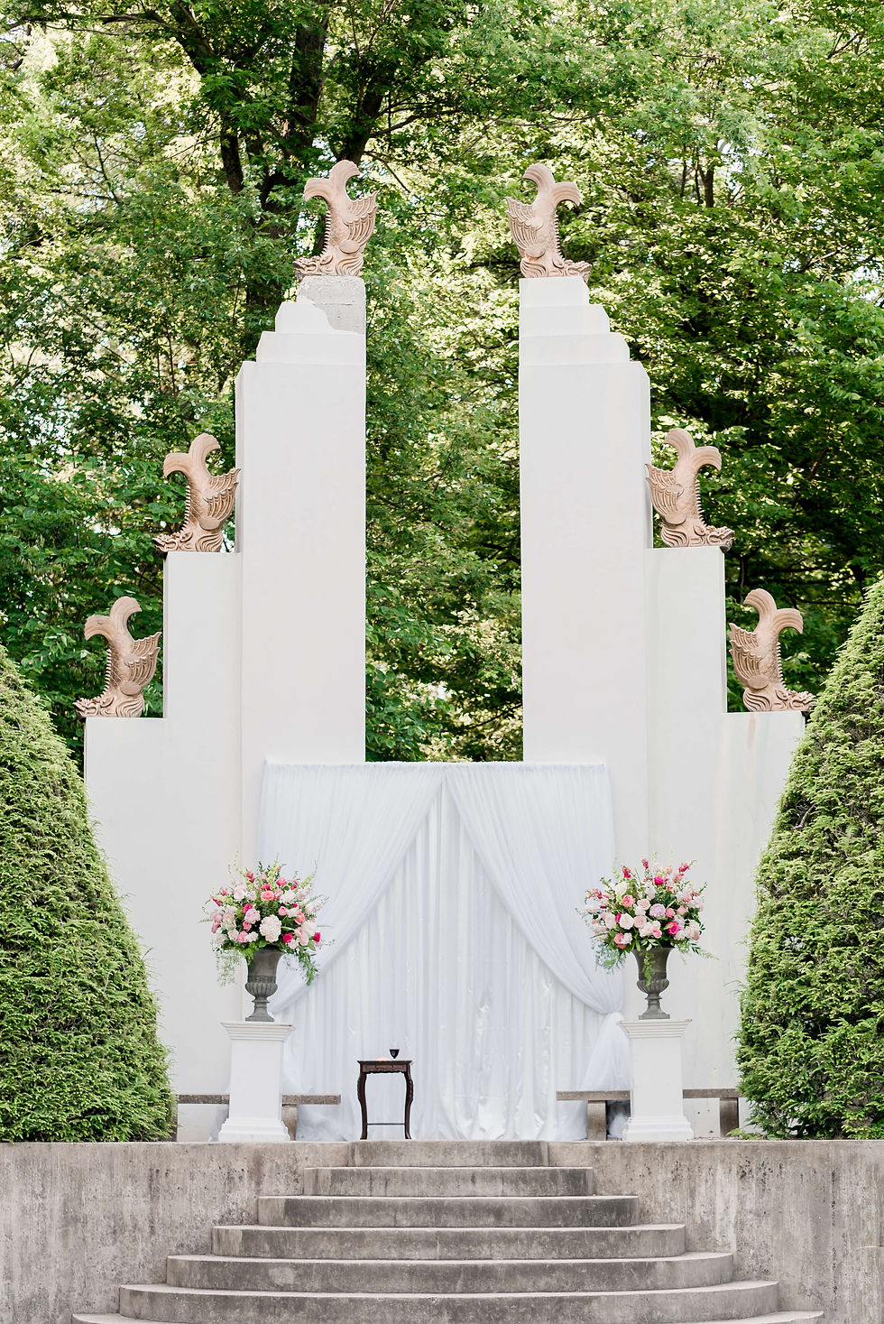 A modern wedding ceremony archway in a sunken garden
