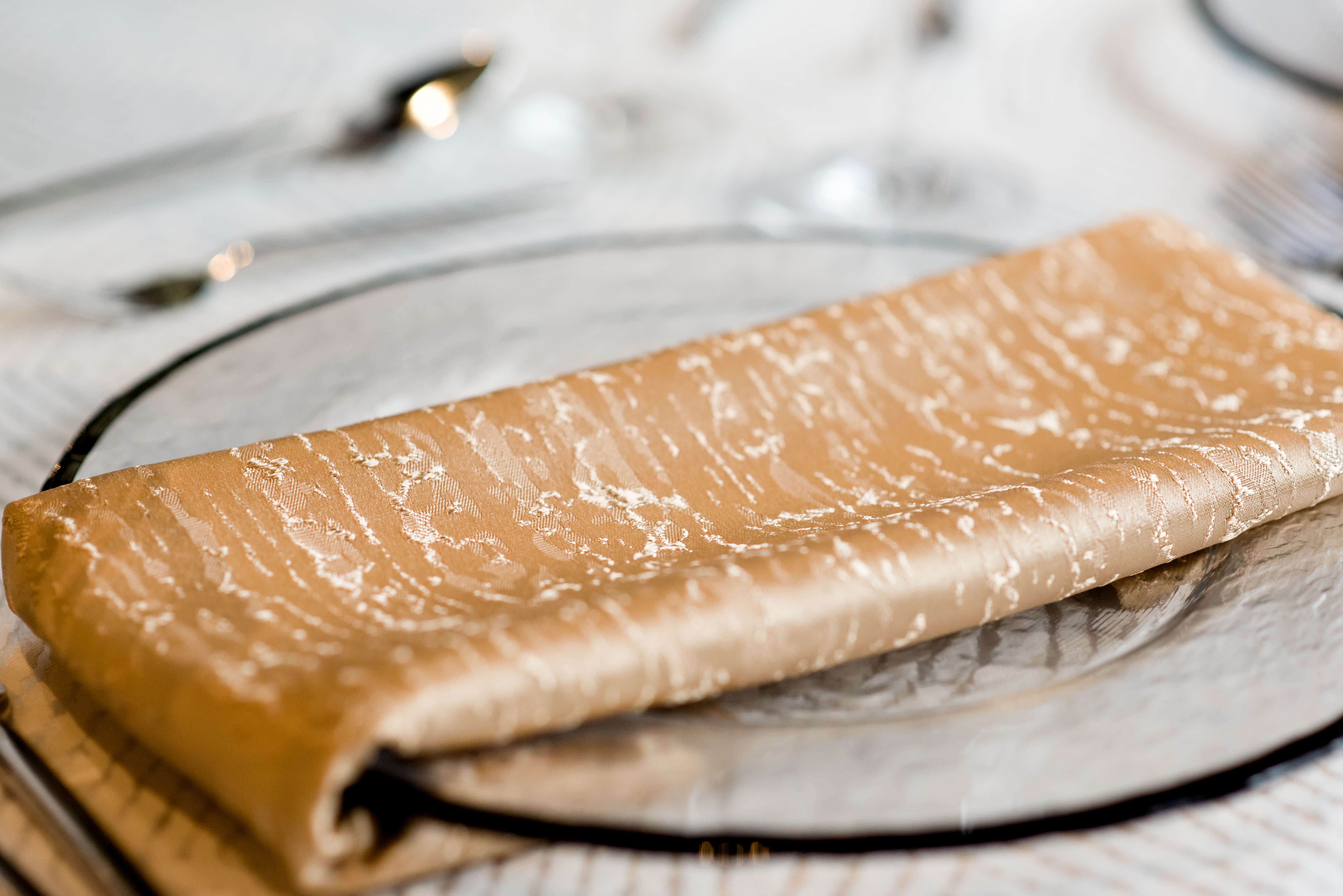 A wedding charger with gold napkin 