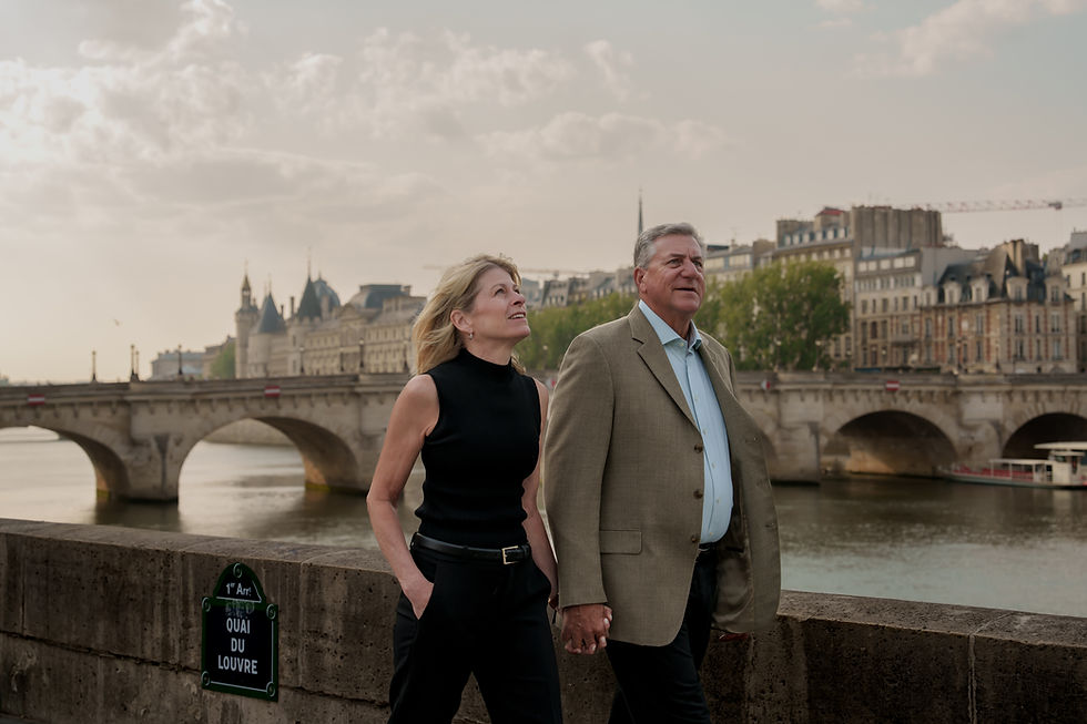 Eye-level view of a couple walking hand in hand along the Seine riverbank