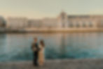 A couple shares a tender moment by the Seine River, framed by the charming architecture and serene waters, creating a romantic and private atmosphere.