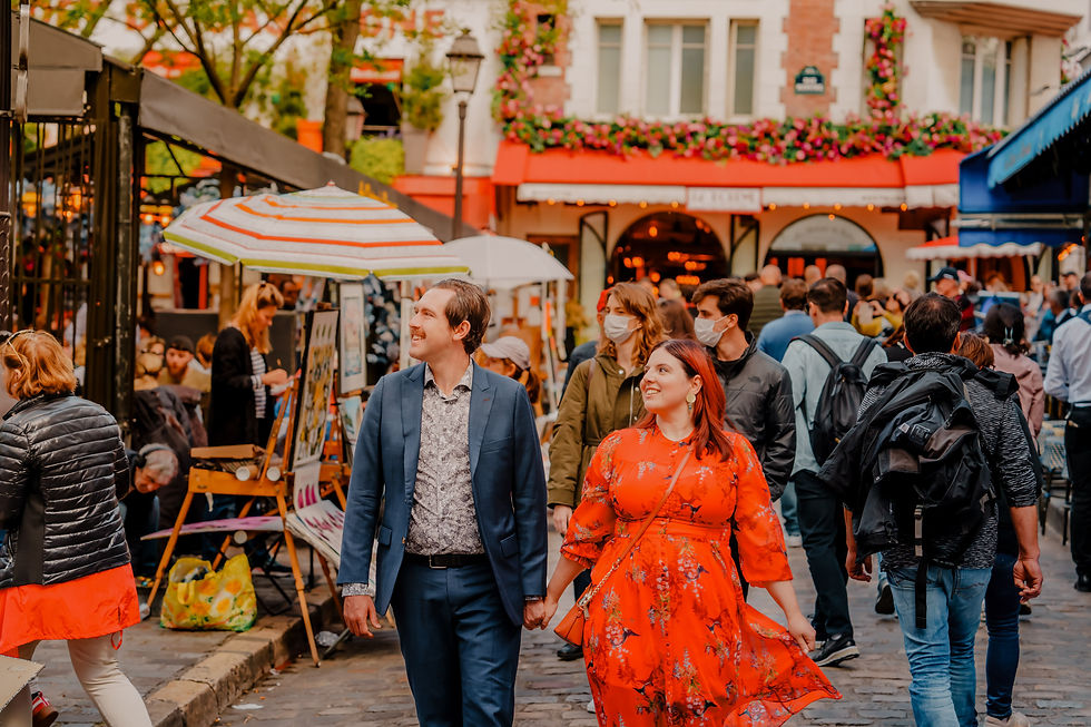 A couple strolls hand in hand through the vibrant and bustling streets of Montmartre, surrounded by colorful umbrellas and lively crowds. Photo by lovidovi.art