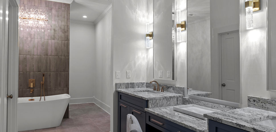 Luxe bathroom with extra long vanity, sleek mirrors, and an inviting soaking tub