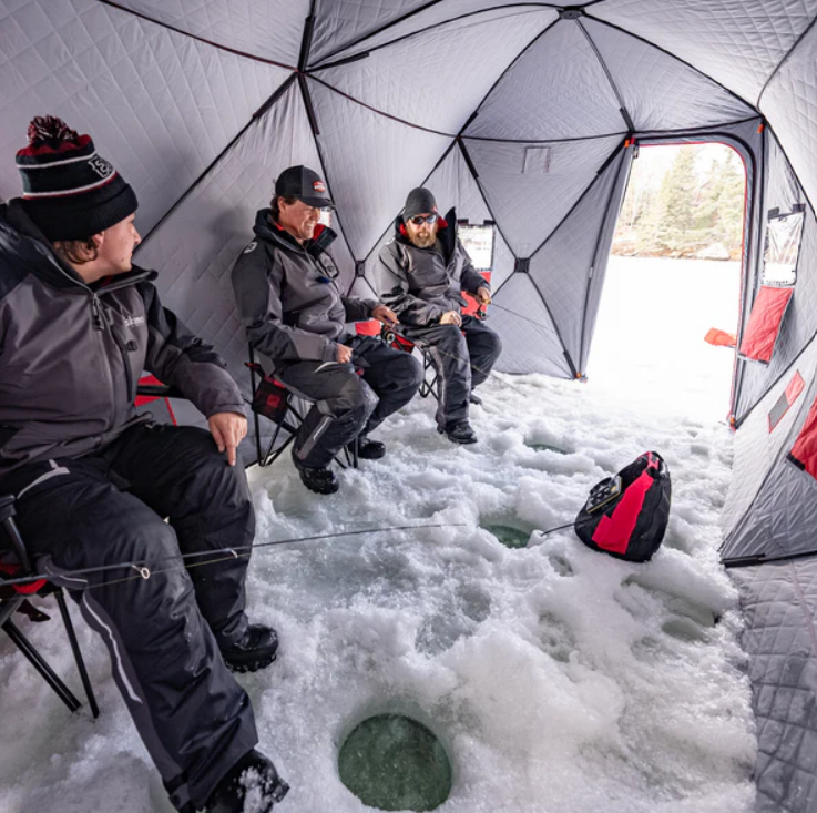men ice fishing inside an ice shelter