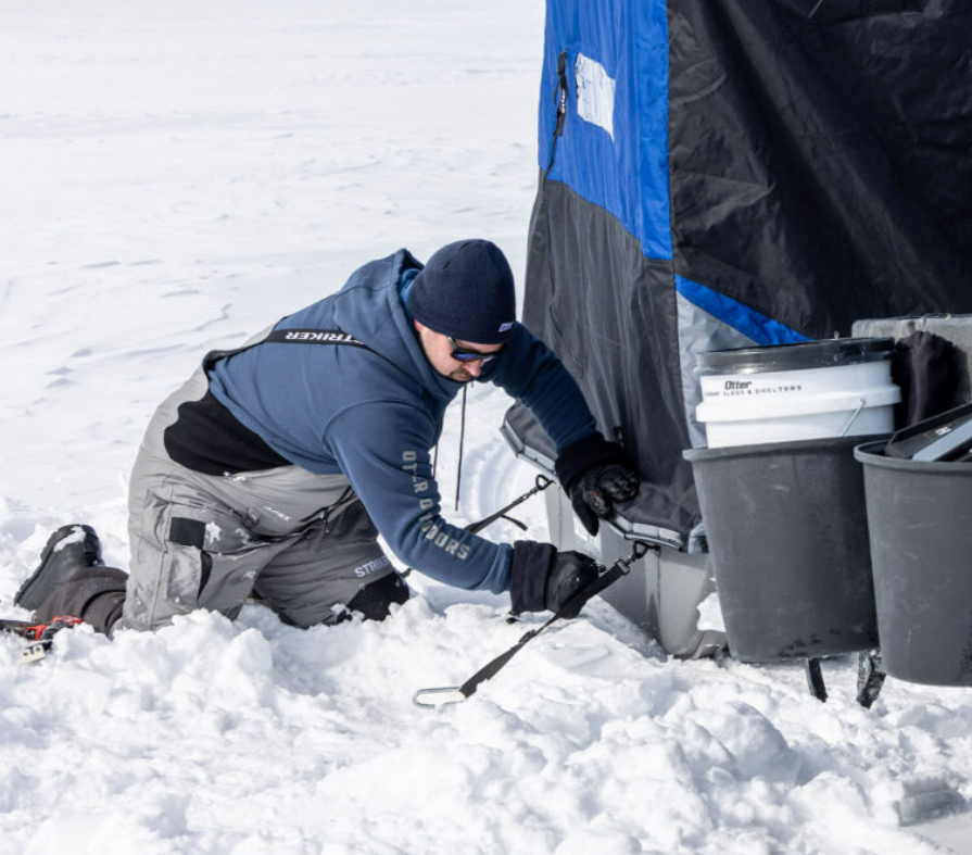 a man securing his ice shelter