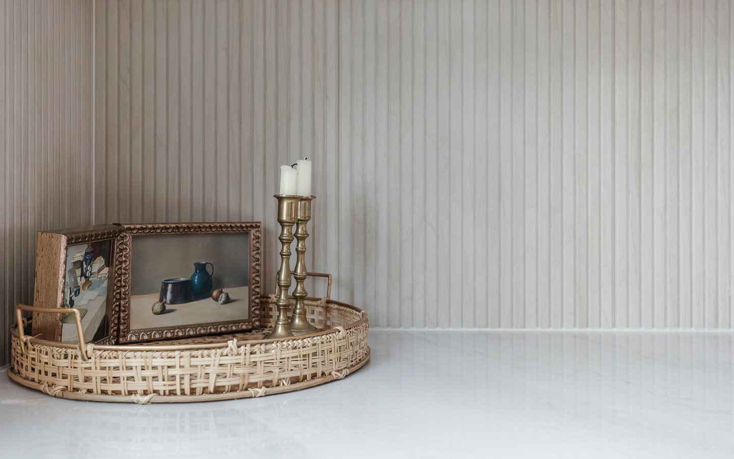 Woven tray with framed art and brass candlesticks