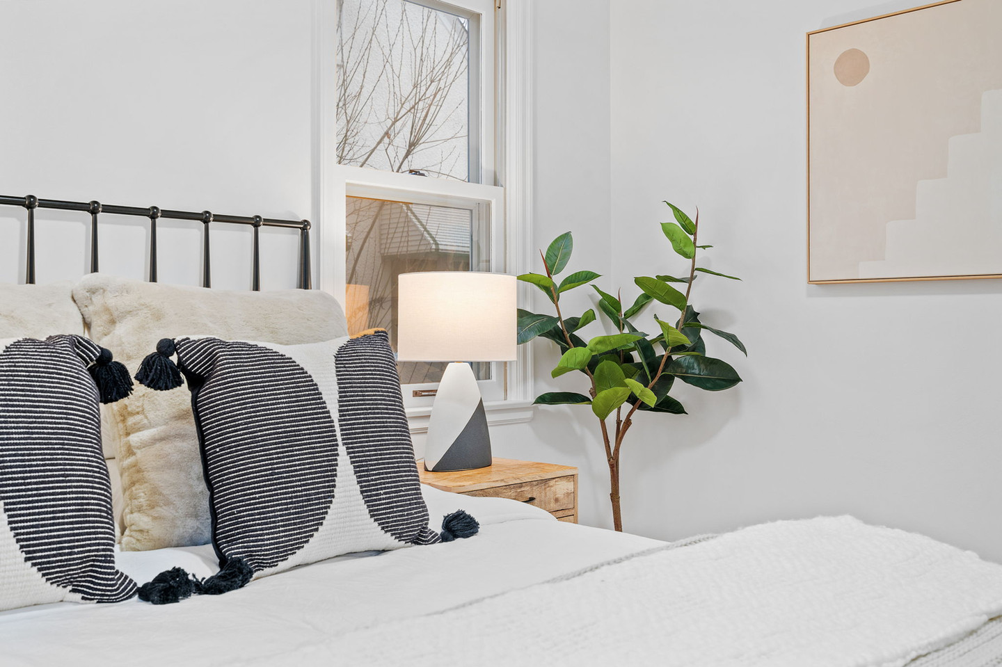 Modern bedroom with patterned pillows and bedside lamp