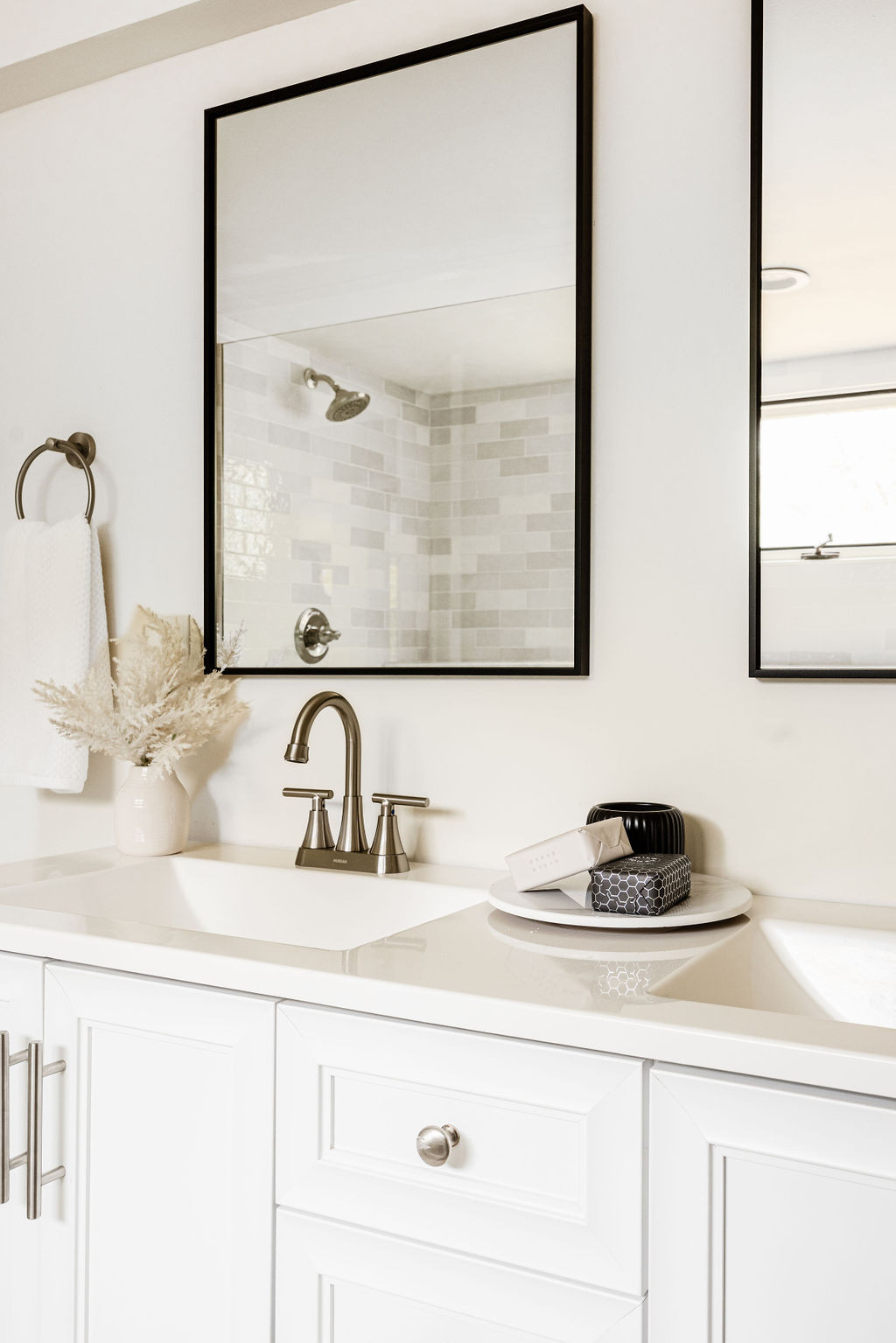 Bathroom vanity with sink, faucet, and mirror reflecting a shower