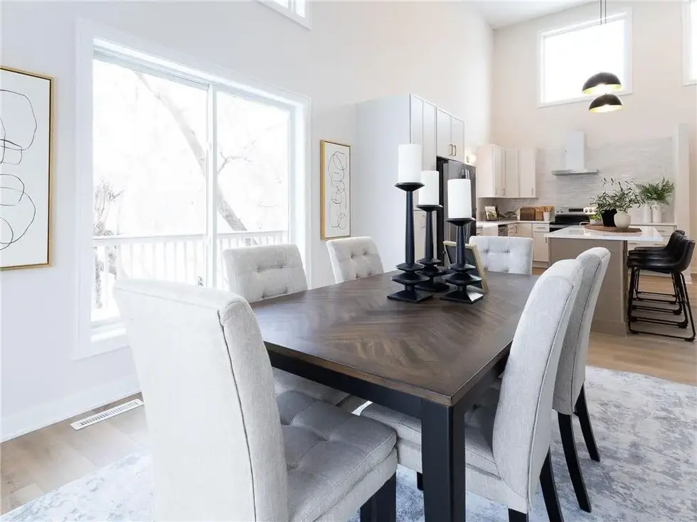 Open concept dining room with vaulted ceilings and back patio door leading to the deck