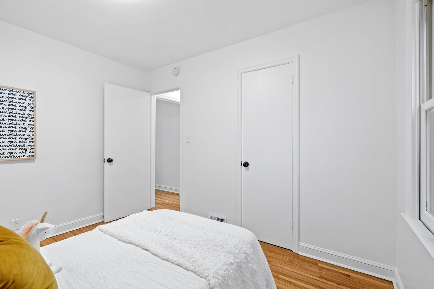 White bedroom with a minimalist bed and two doors