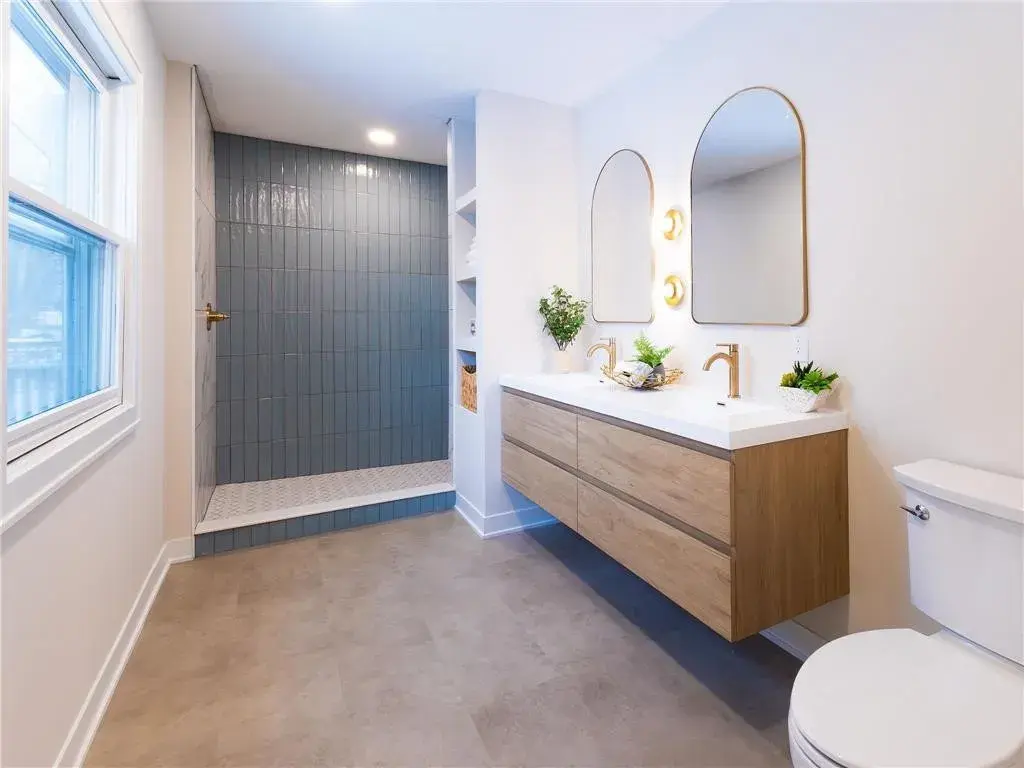Dual sink vanity, blue tile shower, open shelving