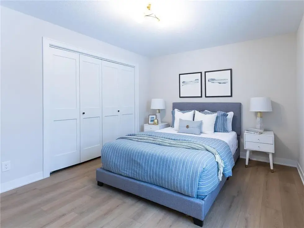 Styled bedroom with end tables and blue accents in decor
