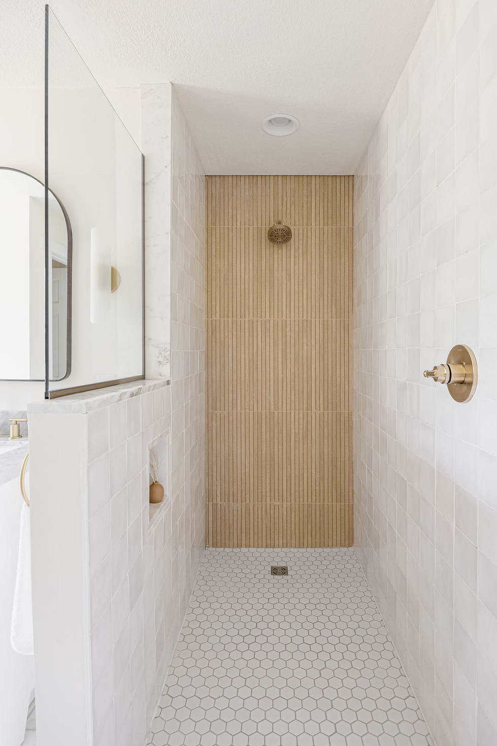 Modern shower with vertical wood-look tiles and gold fixtures