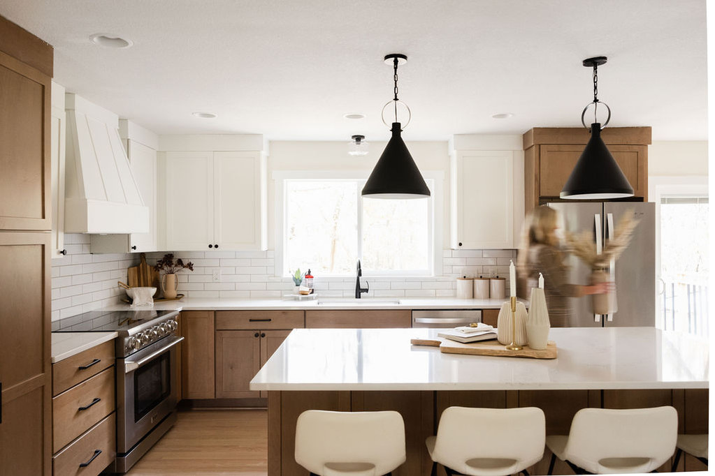 Modern kitchen with two-tone cabinets, island, black pendants
